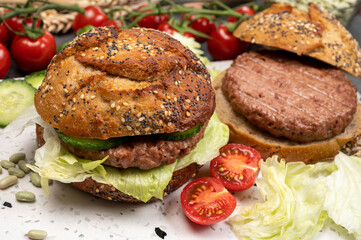Making tasty vegetarian vegan hamburger from plant based soya beans burger, organic bun with seeds and fresh vegetables