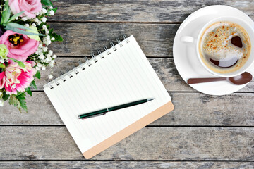 Empty notebook with pen, coffee cup and colorful flowers on table