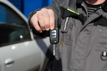 Car keys in the hands of a car mechanic.Car maintenance.