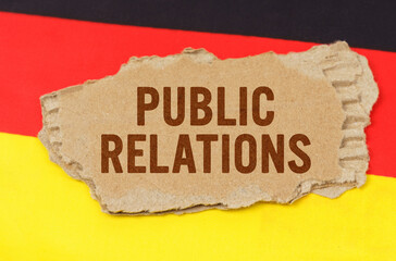 Against the background of the German flag lies cardboard with the inscription - Public Relations