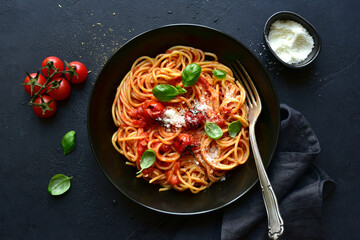 Spaghetti pasta with gilled tomatoes, garlic and sauce. Top view with copy space.