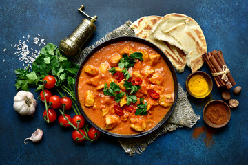 Chicken tikka masala - traditional dish of indian cuisine in a black bowl.Top view with copy space.