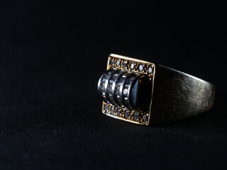 Closeup shot of a men's ring encrusted with diamonds isolated on a black background
