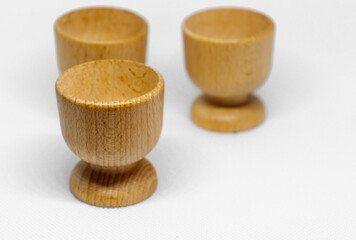 Three empty rustic wooden cups on a white background, photographed from the front