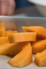sharp knife chopping through a pile of canteloupe chunks