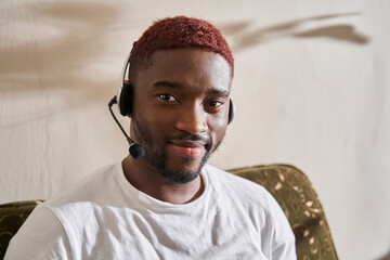 Man wearing headphones looking at the camera with pleasure smile