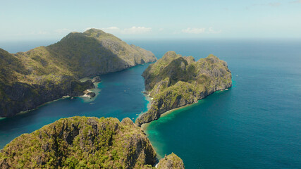 Obraz premium Bay and the tropical islands. Seascape with tropical rocky islands, ocean blue wate, aerial view. islands and mountains covered with tropical forest. El nido, Philippines, Palawan. Tropical Mountain