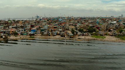 Slum area near the port in Manila, Phillippines, top view. lot of garbage in the water.