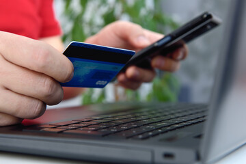 Businessman hands using mobile phone and holding credit card.