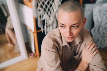 Woman sitting at the floor and looking away while posing at the camera