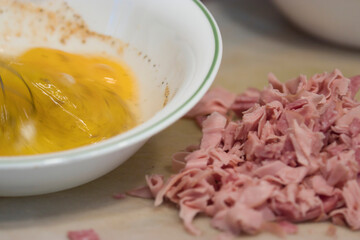 rapidly stirring raw eggs in a bowl with a whisk