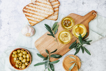 Olive Oil. Organic olive oil in bowl with green olives, herbs, spices and ciabatta bread on white background , banner, healthy mediterranean food concept...
