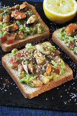 Open sandwiches with guacamole and mussels. Healthly food. The keto diet.