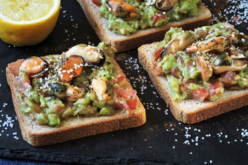 Open sandwiches with guacamole and mussels. Healthly food. The keto diet.