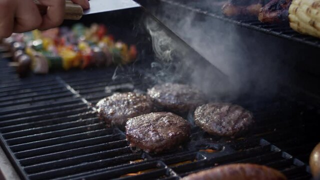 Huge flames engulf juicy grilled burgers at a summer cookout