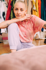 Obraz premium Woman wearing domestic clothes sitting at the floor while posing to the camera