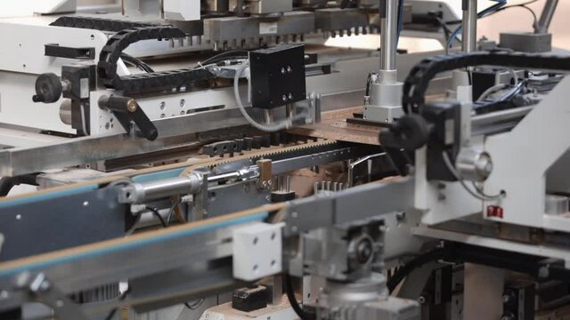 Conveyor machine for the production of furniture made of chipboard. Technological process of production automation. Close-up of working mechanisms