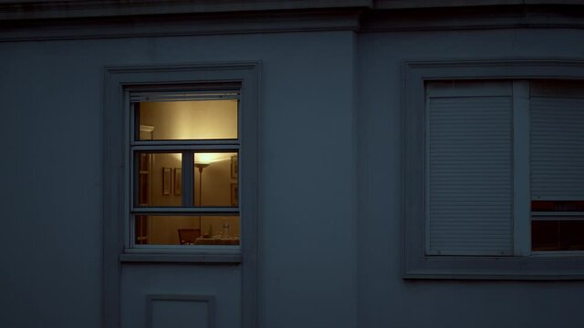 House window with dim light in the dusk