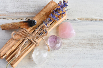 A close up image of holy wood incense sticks with healing rose quartz and amethyst crystals.  - obrazy, fototapety, plakaty