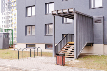 Entrance to a new apartment building. Entrance with bicycle parking and urn. Entrance to the house by stairs.