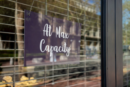 At Max Capacity Sign At The Entrance To A Retail Store When Maximum Occupancy Is Reached During The Coronavirus Pandemic.