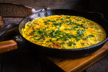 Rustic omelet with potatoes in a cast-iron pan cooked in the oven.