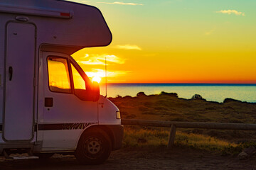 Camper vehicle on beach at sunrise