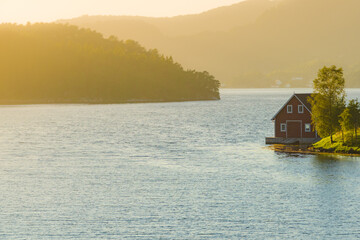 Obraz premium Wooden cabin on fjord shore, Norway