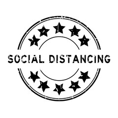 Grunge black social distancing word with star icon round rubber seal stamp on white background
