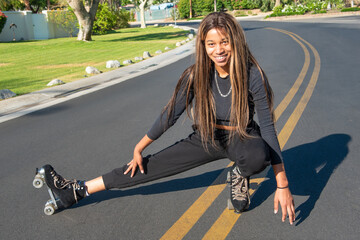 Young African-American women with roller skates posses on the street