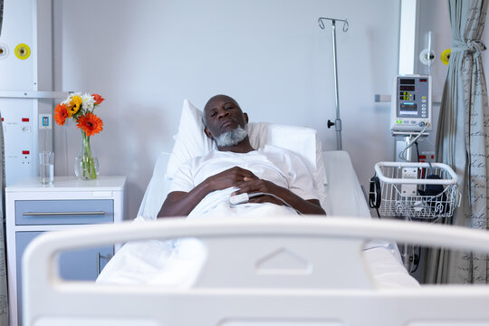 Portrait of african american male patient lying on hospital bed looking to camera
