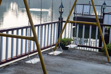  Empty Old metal chain swing for chidren on the pier in the Hotel