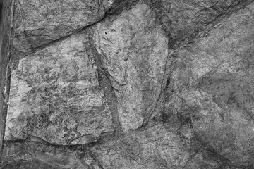 A black and white photograph background of  stone wall. Part of stone wall for background or texture.