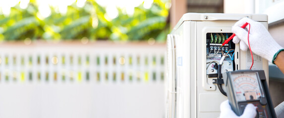 Close up technician hand using measuring equipment checking electric current voltage at circuit...