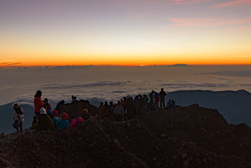 People on the summit of volcano Rinjani watching sunrise, Lombok, Indonesia 