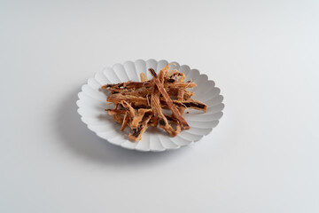 白い背景で撮影された酒とおつまみ（あたりめ
