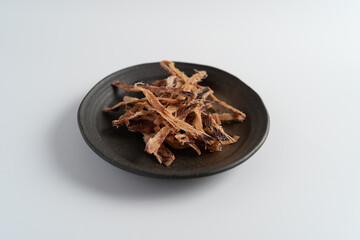 白い背景で撮影された酒とおつまみ（あたりめ
