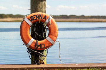 A lifebuoy attached to a dock post on the pier in Vienna, Maryland. This is a historic colonial era...