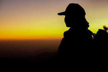Silhouette of a person watching the sunset in the mountains