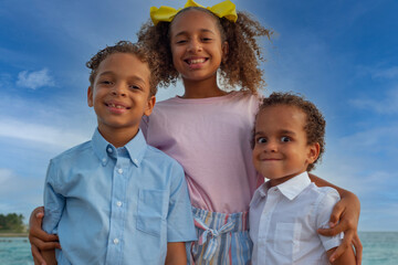 A sister and two brothers posing for a shot