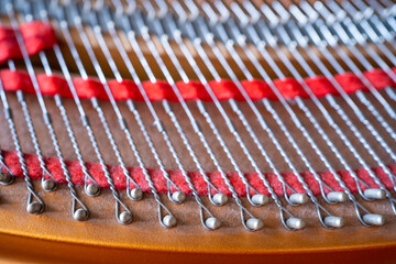 Close up image of interior of grand piano showing strings and structure