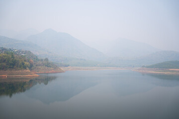 Beautiful  lake with reflection of the  mountains, smog and polluted air pollution from particle PM2.5