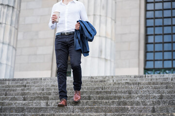 Businessman holding a cup of coffee on way to work.