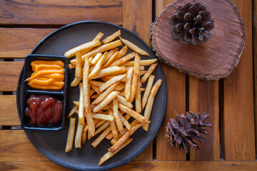 French fries in a bowl on a wooden background