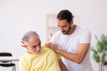 Fototapeta premium Old male patient visiting young male doctor chiropractor