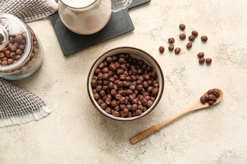 Bowl with chocolate corn balls on light background