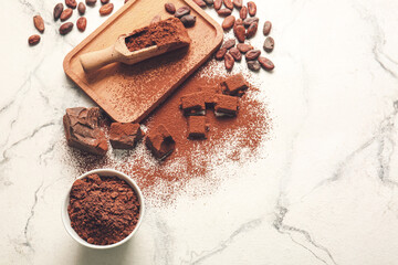 Beans, chocolate and cocoa powder on light background