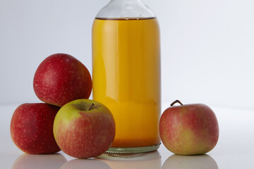 apple cider vinegar and fresh apples on white background