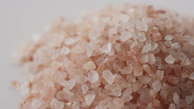 Close up of pink sea salt rotating in a pile