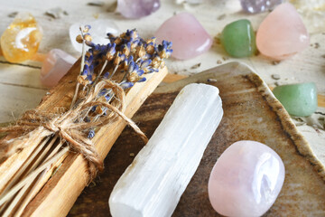 A close up image of Palo Santo incense sticks with dried lavender and healing crystals on a white background.  - obrazy, fototapety, plakaty